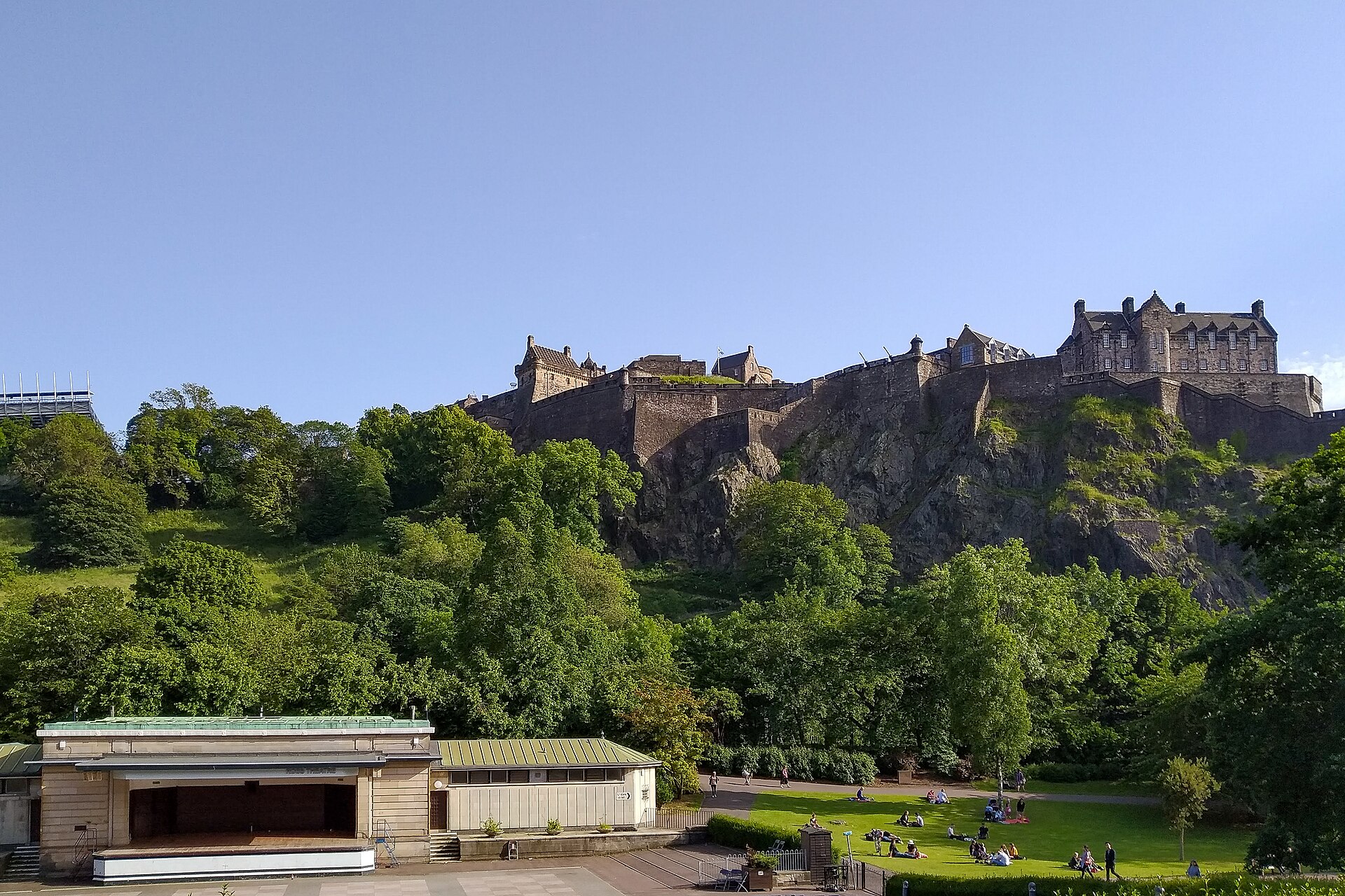 Edinburgh Castle on its rock above the trees and lawns of Princes Street Gardens on a sunny day